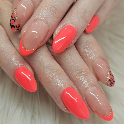 Close-up of hands with bright coral nail polish and decorative accents on a neutral background