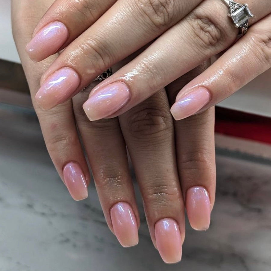 Close-up of hands with pink nail polish on a blurred background