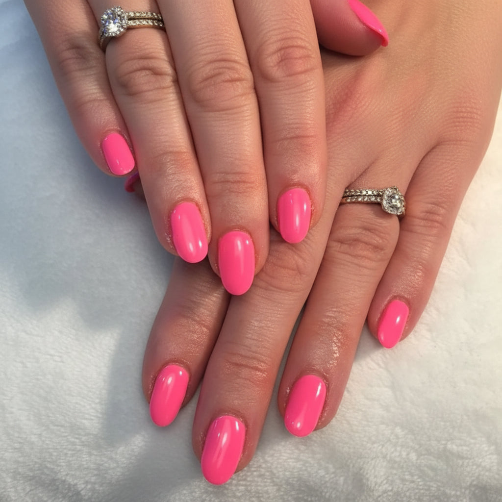 Close-up of hands with pink nail polish on a neutral background