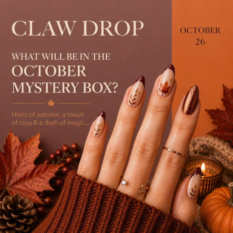 Promotional graphic for a claw drop mystery box in October, featuring a hand with autumn-themed nail art, fall leaves, a candle, and a small pumpkin against a brown and orange background with the text 'CLAW DROP' and 'OCTOBER 26'.
