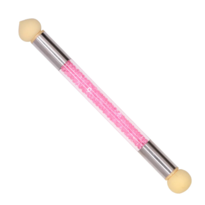 Double-ended blender nail brush with pink handle and beige bristles on a white background