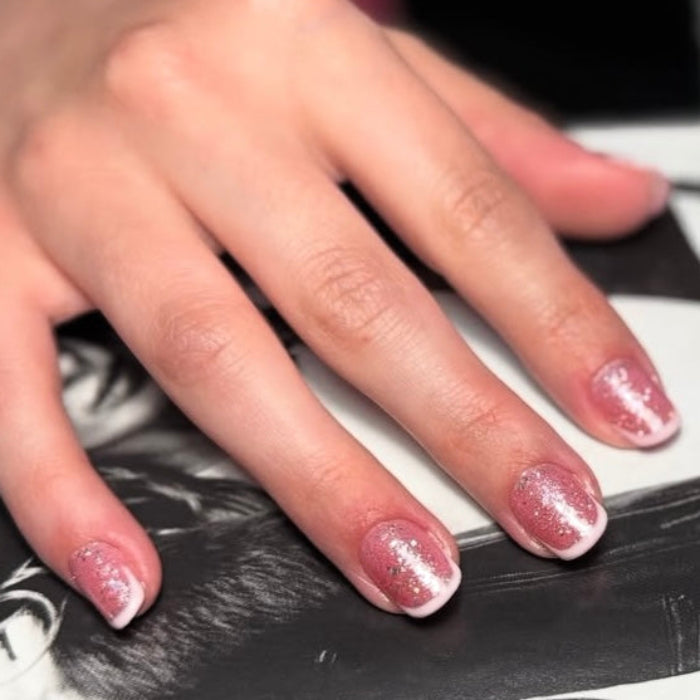 Close-up of hands with pink nail polish on a black and white background