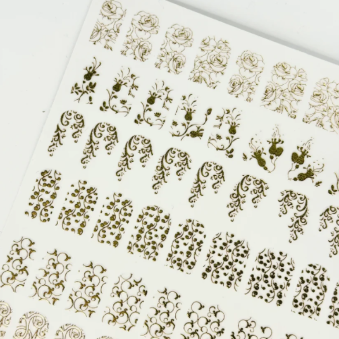 Sheet of gold floral nail art stickers on a white background