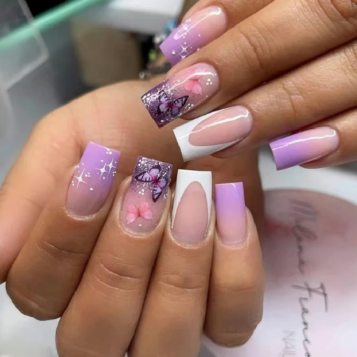 Nails with pink and purple gradient design featuring butterflies and flowers.