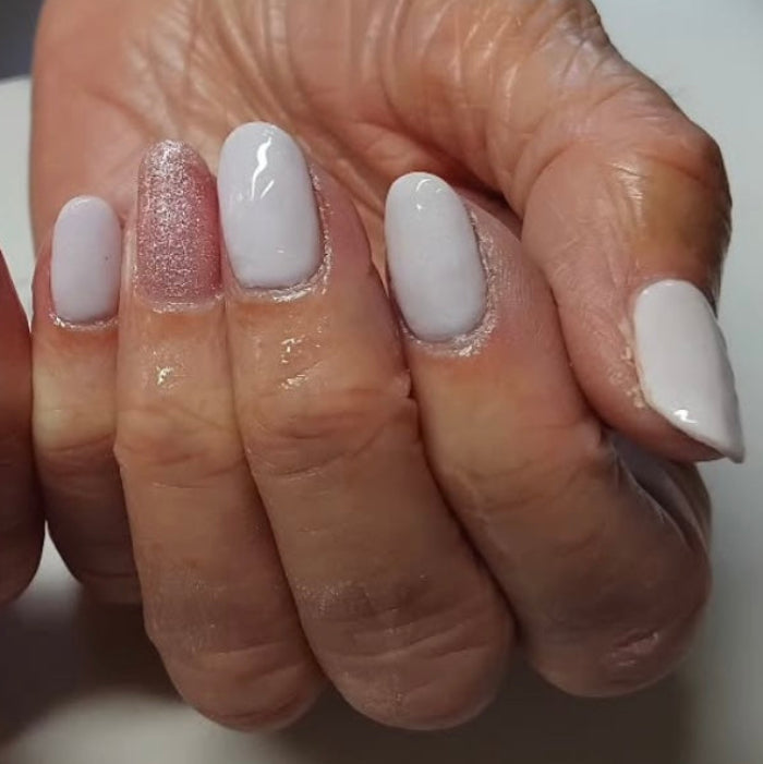 Close up of hand with a neutral gel polish on finger nails 