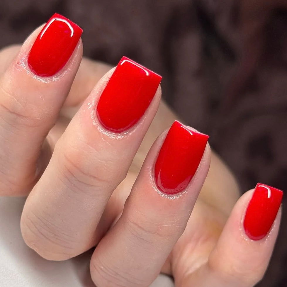 Hand with red gel polish on finger nails 