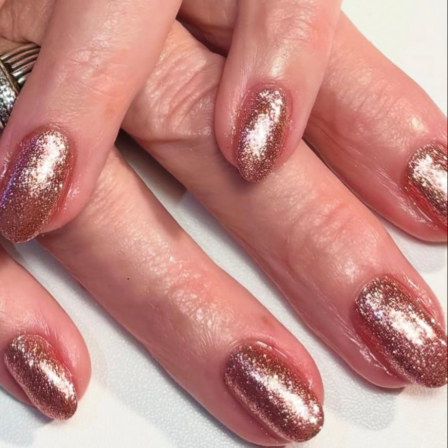 Rose gold sparkly nails on a light background 