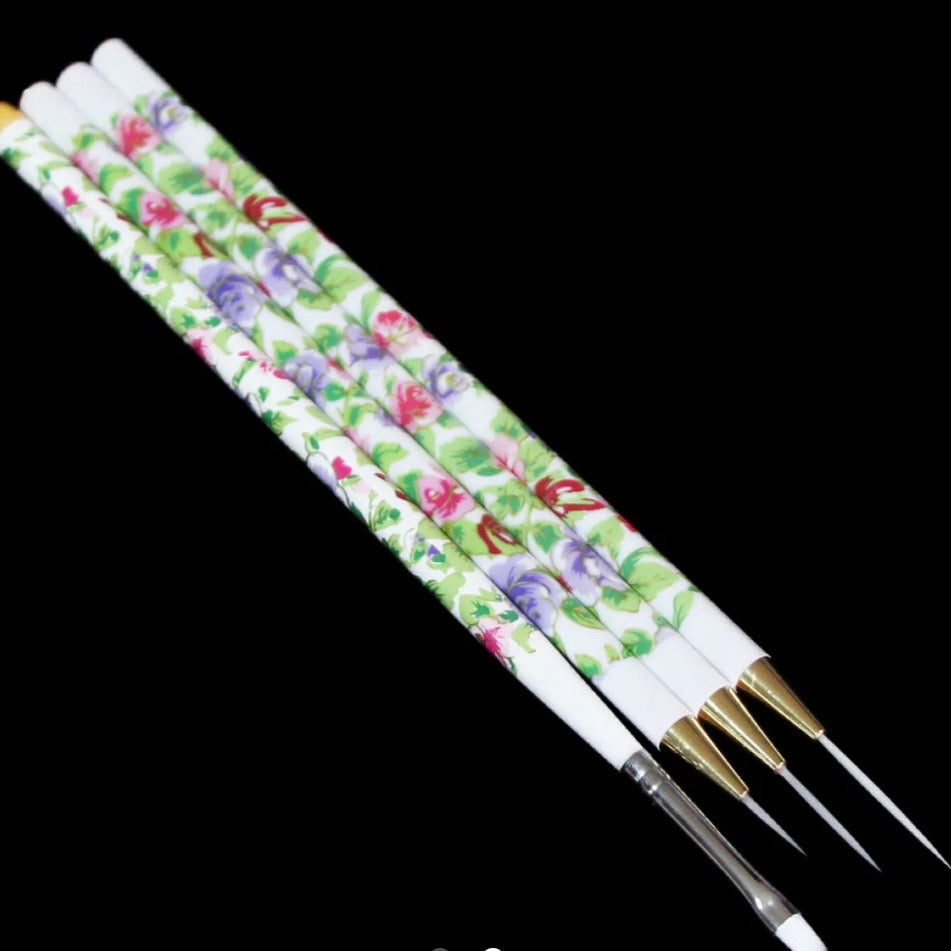 Set of nail art brushes with floral patterned handles on a black background