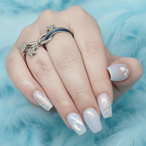 A nail set with a pale blue design with baby footprints on a blue feathery background