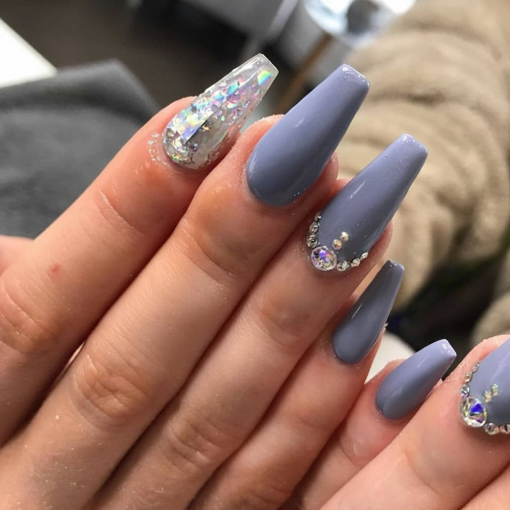 Hand with grey acrylic nails featuring rhinestones.