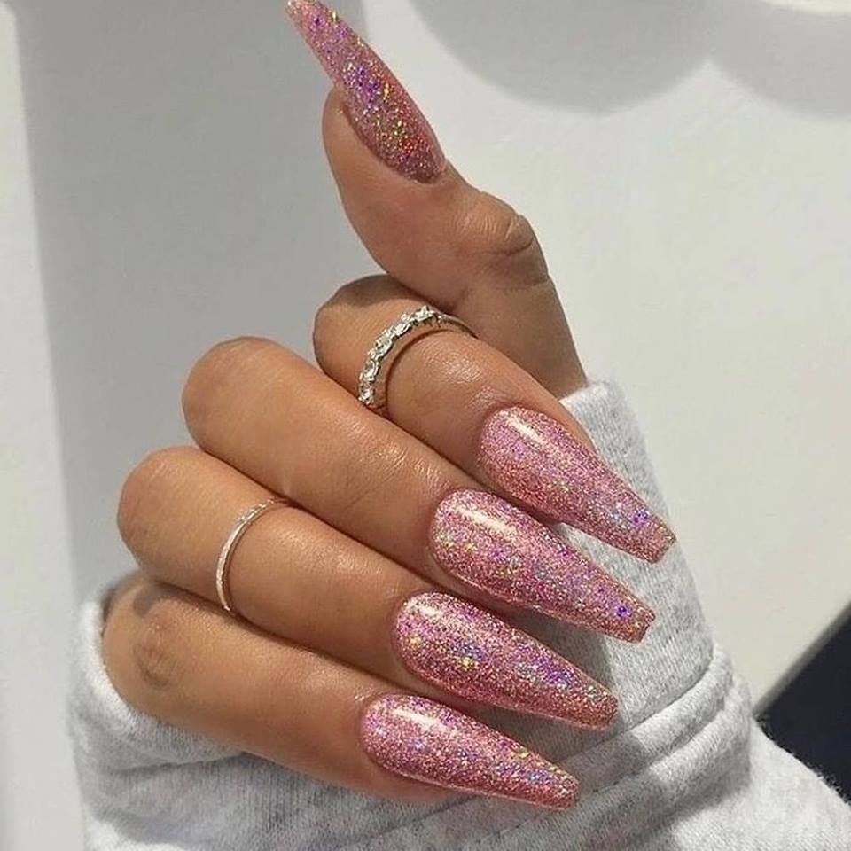 Close up of a hand featuring a glittery pink gel polish on the nails  