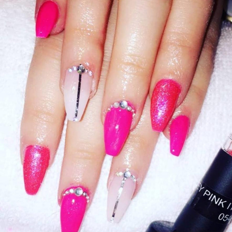 Hands with pink shimmery nails on a white background 